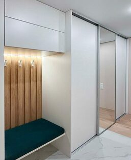 Белый шкаф-купе с подсветкой входной зоны, вид сбоку Встроенный шкаф-купе в прихожей